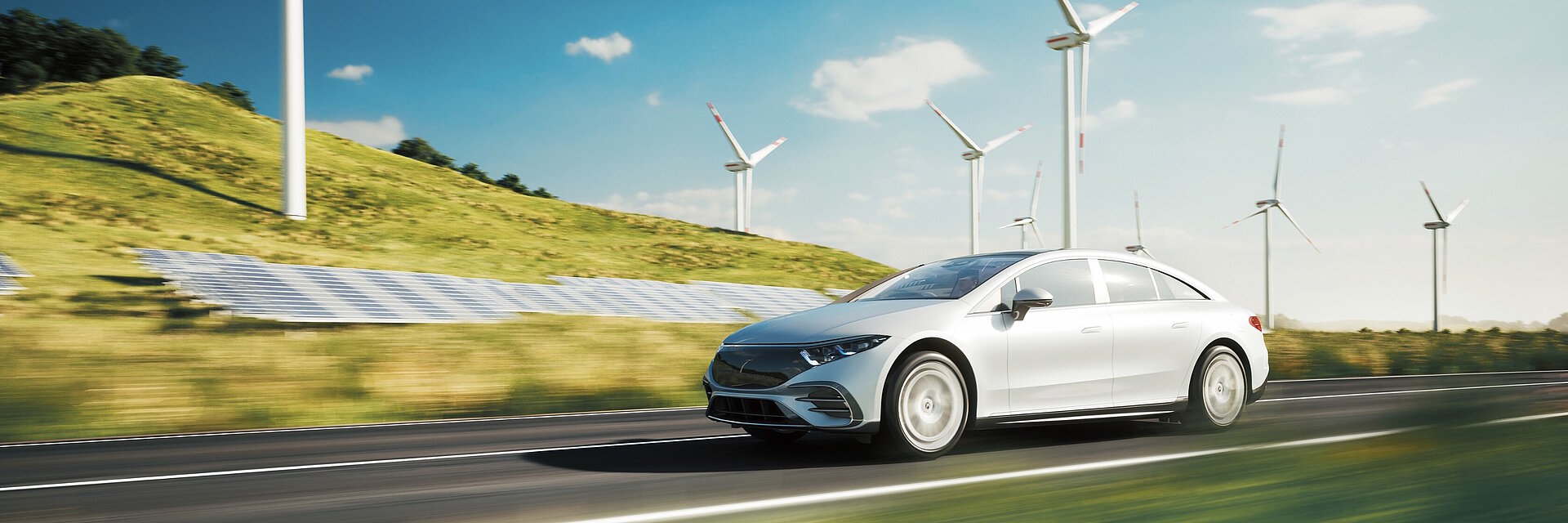 Electric sports car drives past solar panels and wind turbines